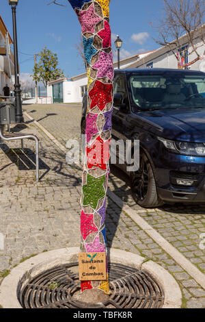 Laine laine crochet en forme d'étoile autour de tronc d'arbre dans la rue de village Mertola, Portugal Banque D'Images