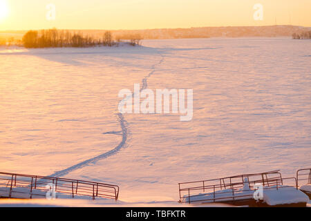 Champ d'hiver coucher de soleil sur sentier. Banque D'Images