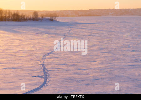 Champ d'hiver coucher de soleil sur sentier. Banque D'Images