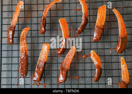 Grille avec des délicieuses couverts d'oranges sur le tableau noir Banque D'Images