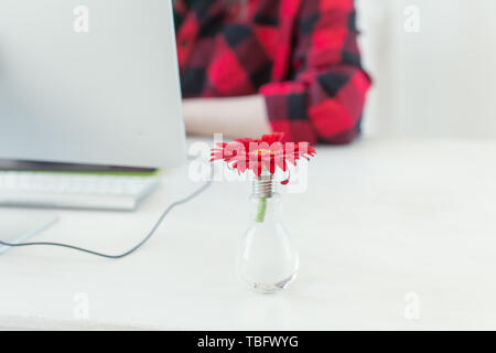 Lieu de travail avec gerbera flower et l'ordinateur. Bureau d'accueil minimaliste avec des articles sur l'arrière-plan Banque D'Images