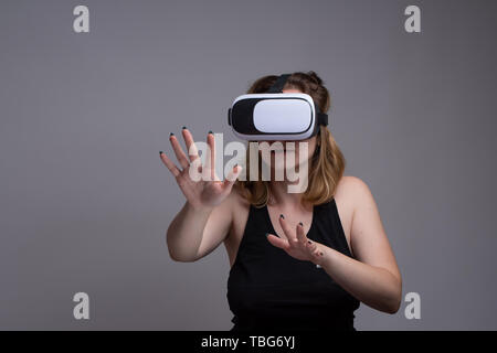 Les jeunes femmes aux prises avec le cyberespace et l'interaction avec la réalité virtuelle lors de l'utilisation d'un casque VR Banque D'Images