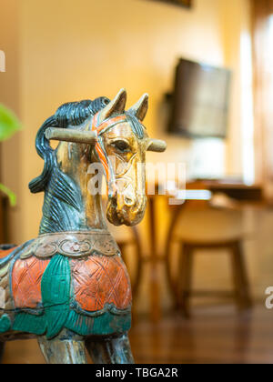 Cheval en bois sculpté ancien décoré en face de la chambre avec la lumière wam. Banque D'Images