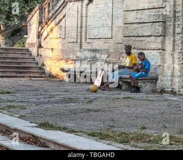 France, Montpellier - 17 juin 2018 : les migrants en Europe.Le père apprend à jouer la guitare enfant noir dans la rue à Montpellier, France Banque D'Images