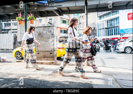 3 touristes asiatiques font leur chemin à travers le quartier animé de Sukhumvit Road Bangkok, Thaïlande. Banque D'Images