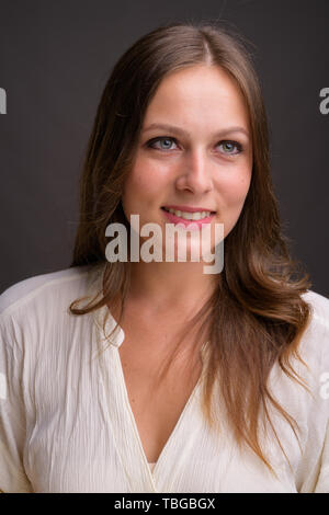 Studio shot of young Beautiful woman contre l'arrière-plan gris Banque D'Images