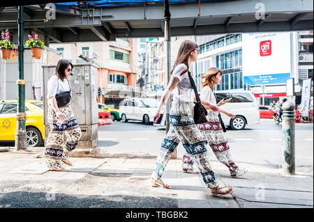 3 touristes asiatiques font leur chemin à travers le quartier animé de Sukhumvit Road Bangkok, Thaïlande. Banque D'Images