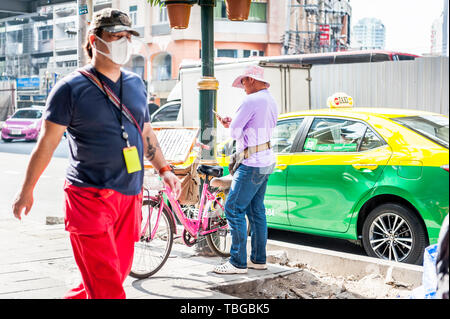 Un vendeur de billets de loterie voyages par Bangkok sur sa bicyclette pour vendre des billets sur Sukhumvit Road en Thaïlande. Banque D'Images