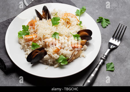 De délicieux fruits de mer risotto aux crevettes, crevettes, moules. Habillé de fromage parmesan et le persil Banque D'Images