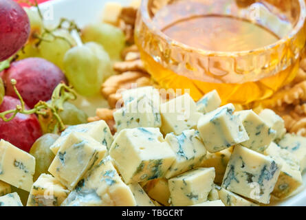 Différents types de fromage, raisins, noix et miel assortiment gastronomique close-up Banque D'Images