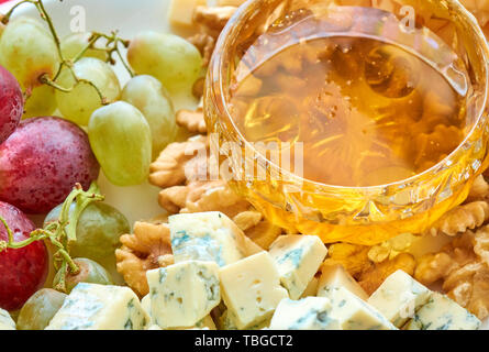 Différents types de fromage, raisins, noix et miel assortiment gastronomique close-up Banque D'Images