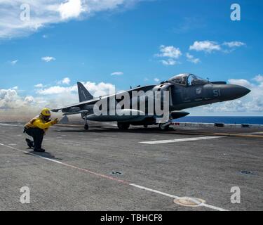 190529-N-PX867-1418 de l'OCÉAN PACIFIQUE (29 mai 2019) l'Aviation maître de Manœuvre (manutention) 1re classe Dustin Shead, de Dallas, Texas, affecté à un navire d'assaut amphibie USS Boxer (DG 4), signale un AV-8B Harrier attaché à rotors basculants moyen maritime (VMM) de l'Escadron 163 (renforcée) en préparation pour un vol au-dessus avec deux U.S. Air Force B-52 Stratofortress aéronefs affectés au 23e Escadron de bombardement de la Force expéditionnaire du Canada. Le groupe amphibie Boxer (ARG) et 11e Marine Expeditionary Unit (MEU) sont déployés dans le domaine de la 7ème flotte américaine à l'appui des opérations de la stabilité régionale, de rassurer la partie Banque D'Images