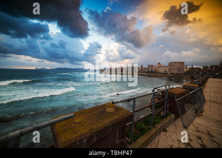 Des nuages sombres sur Alghero au coucher du soleil. La Sardaigne, Italie Banque D'Images