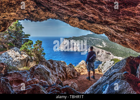 Randonneur avec sac à dos par une grotte dans la région de Capo Caccia. La Sardaigne, Italie Banque D'Images