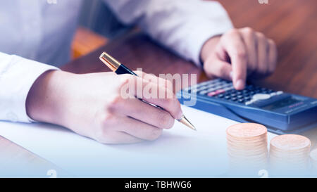 Hommes d'utiliser des calculatrices, papier et stylos pour les rapports d'analyse financière Banque D'Images