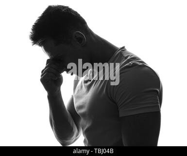 Silhouette de jeune homme réfléchi sur fond blanc Banque D'Images