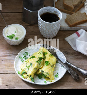 Petit-déjeuner fait maison composé d'omelette aux asperges et d'oignons et du café chaud. De style rustique, selective focus. Banque D'Images