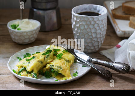 Petit-déjeuner fait maison composé d'omelette aux asperges et d'oignons et du café chaud. De style rustique, selective focus. Banque D'Images