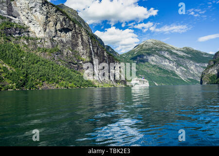 Vue sur le Geirangerfjord avec un bateau de croisière naviguant sous la magnifique cascade, Sœur Sept Sunnmore, More og Romsdal (Norvège) Banque D'Images