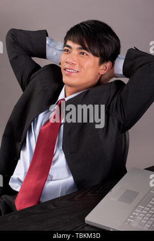 Un homme travailleur en col blanc et d'un ordinateur portable. Banque D'Images