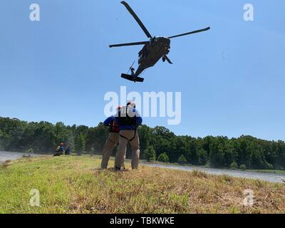 Les membres du Groupe de travail 2 du Mississippi, de recherche et de sauvetage en milieu urbain, effectuer des opérations de levage au-dessus de l'eau avec un hélicoptère Blackhawk UH-60 le 31 mai 2019 au Camp McCain, du Mississippi au cours de l'exercice Ardent Sentry. Ardent Sentry 2019 est un commandement de la défense aérospatiale de l'Amérique du Nord et le Commandement du Nord des États-Unis exercice était axé sur l'appui de la défense aux autorités civiles pendant une simulation de tremblement de terre de New Madrid Zone Sismique menée pour renforcer la réponse du Mississippi aux catastrophes naturelles. La Garde nationale du Mississippi (Photo par le Sgt. Shawn Keeton) Banque D'Images