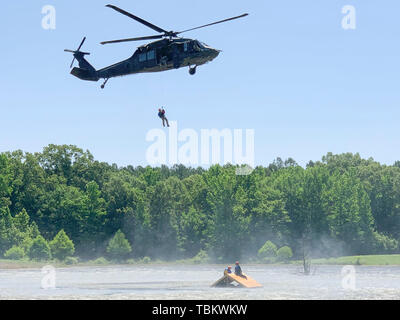 La Garde nationale du Mississippi hélicoptère Blackhawk UH-60 aide les membres du Groupe de travail 2 du Mississippi, en matière de recherche et de sauvetage au-dessus de l'eau au cours de la formation en sauvetage sur le toit 31 mai 2019 au Camp McCain, du Mississippi au cours de l'exercice Ardent Sentry. Ardent Sentry 2019 est un commandement de la défense aérospatiale de l'Amérique du Nord et le Commandement du Nord des États-Unis exercice était axé sur l'appui de la défense aux autorités civiles pendant une simulation de tremblement de terre de New Madrid Zone Sismique menée pour renforcer la réponse du Mississippi aux catastrophes naturelles. La Garde nationale du Mississippi (Photo par le Sgt. Shawn Keeton) Banque D'Images