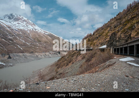 De la dernière neige de l'hiver sur les montagnes à proximité du lac et du barrage sur le grand St Bernard passer entre l'Italie et la Suisse en Europe Banque D'Images