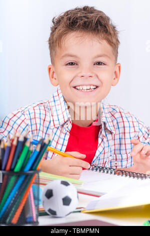 Boy doing homework at desk Banque D'Images