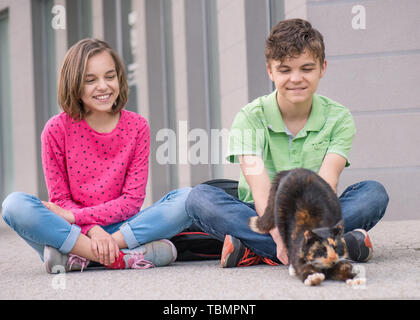 Garçon et fille avec cat en plein air Banque D'Images