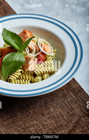 Saumon au four avec des fusillis et épinards. Le concept de la cuisine italienne, classique. Table en conserve magnifiquement avec des pâtes. Banque D'Images