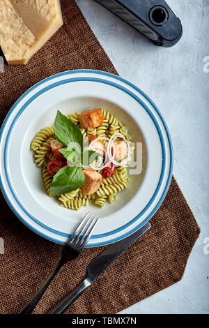 Saumon au four avec des fusillis et épinards. Le concept de la cuisine italienne, classique. Table en conserve magnifiquement avec des pâtes. Banque D'Images