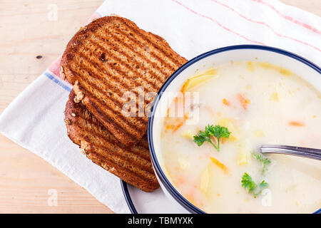 Soupe de fromage en plaque blanche avec du pain grillé Banque D'Images