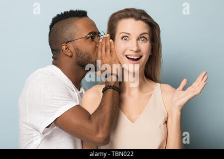 African American man secret à dire choqué caucasian female Banque D'Images