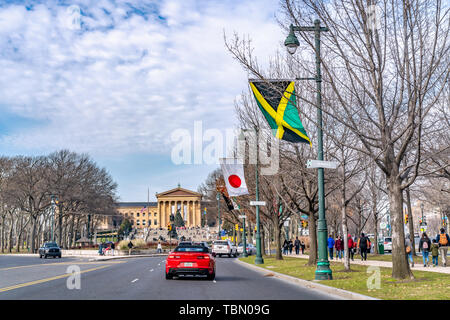 Philadelphie, Pennsylvanie, USA - Décembre 2018 - Avis d'une belle voiture décapotable rouge et des drapeaux du monde le long de la Benjamin Franklin Parkway en bas Banque D'Images