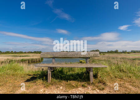 Banc en bois sur le mur nord à Pagham Harbour, West Sussex, UK Banque D'Images