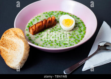 Potage de pois verts (soupe) avec wiener, l'oeuf et du pain grillé Banque D'Images