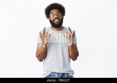 Oui rock. Portrait de Ravi chill et cool african american party guy avec barbe, tatouages et regarder d'or Nez Percé comme showi insouciant souriant Banque D'Images