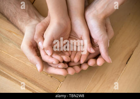 Close up d'aimer maman papa et kid tenir la main sur marbre les paumes vers le haut Banque D'Images
