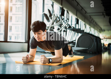 Portrait of Asian man doing Fitness Sport en exercice de planches. Les gens de vie et d'entraînement de sport concept. Banque D'Images