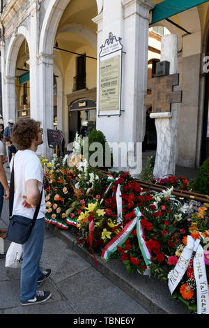 Fleurs fraîches au mémorial des victimes terroristes tuées par les bombardements fascistes en 1974 sur la Piazza della Loggia lors d'une manifestation antifasciste à Brescia. Banque D'Images