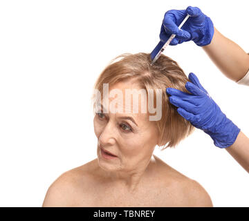 Belle mature woman receiving injection contre fond blanc Banque D'Images