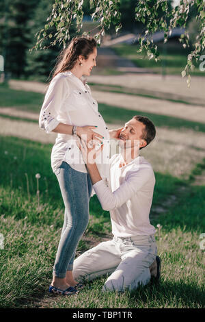 Heureux mari serrant sa femme enceinte pour une promenade dans le parc Banque D'Images