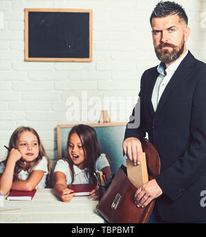 Les jeunes filles d'aider son père avec projet d'école à la maison. homme de réserve en sac. Banque D'Images