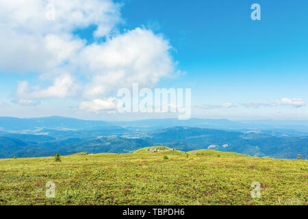 Beau paysage minimal au-dessus des nuages duveteux. pré herbeux plat. rochers sur la crête de montagne. Bosse lointain au loin. merveilleux été scener Banque D'Images