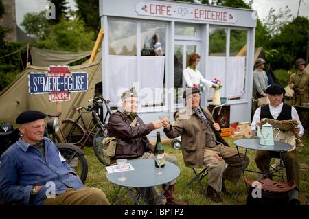 03 juin 2019, la France (France), Sainte Mère Eglise : Les artistes interprètes ou exécutants s'asseoir au Camp Gironimo n'en face de la façade d'un café. Sur environ 14000 parachutistes alliés 06.06.1944 de la 82e Division aéroportée US atterri ici dans le cadre de l'opération Overlord. 06.06.2019 est le 75e anniversaire de le débarquement des troupes alliées en Normandie. Photo : Kay Nietfeld/dpa Banque D'Images