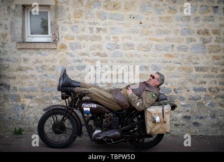 Sainte Mère Eglise, France. 06Th Juin, 2019. Sur une moto historique, un homme en uniforme se trouve en face de l'église de Sainte-Mère-Eglise. Sur environ 14000 parachutistes alliés 06.06.1944 de la 82e Division aéroportée US atterri ici dans le cadre de l'opération Overlord. 06.06.2019 est le 75e anniversaire de le débarquement des troupes alliées en Normandie. Photo : Kay Nietfeld/dpa Banque D'Images