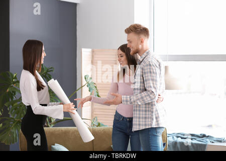 Agent immobilier montrant jeune couple une nouvelle maison Banque D'Images