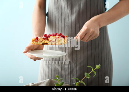 Woman putting morceau de tarte aux canneberges savoureux sur la plaque Banque D'Images