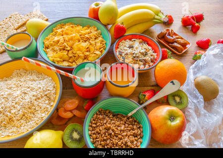 Petit déjeuner santé varié de fruits, céréales, lait, les prunes séchées, fraises et Apple Banque D'Images