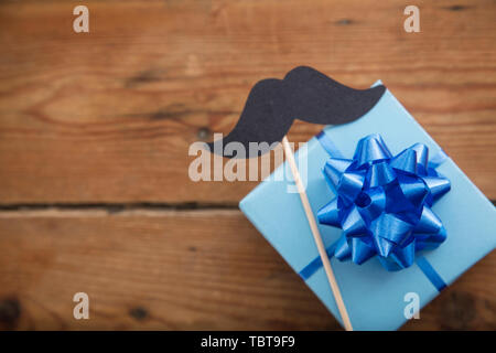 Des pères cadeaux enveloppés de papier bleu avec moustache. Happy father's day background Banque D'Images